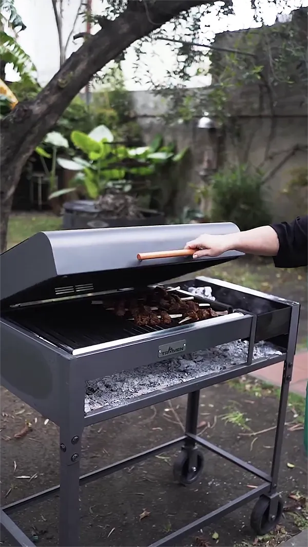A person holding a grill lid