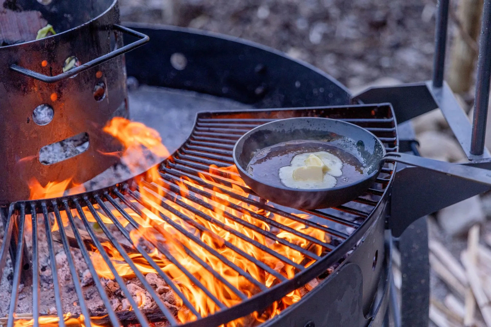 Steel skillet over a rotisserie with melted butter