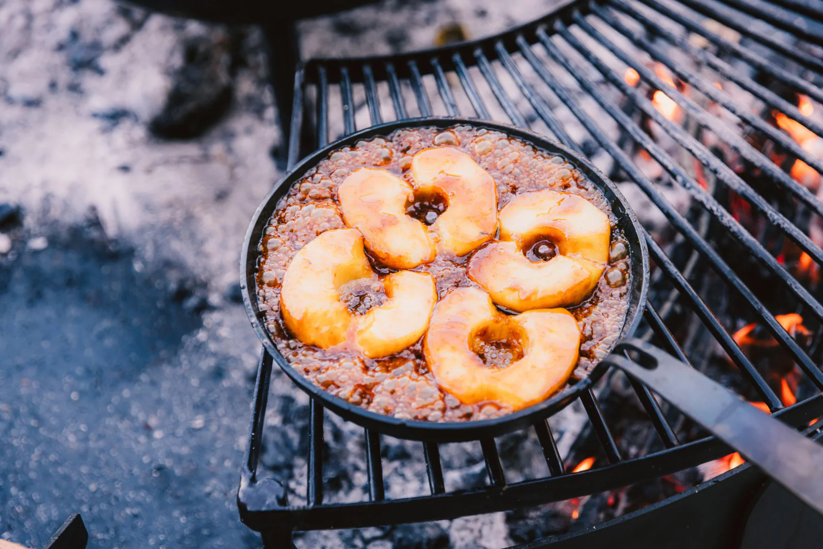 Steel frying pan with food on a spit